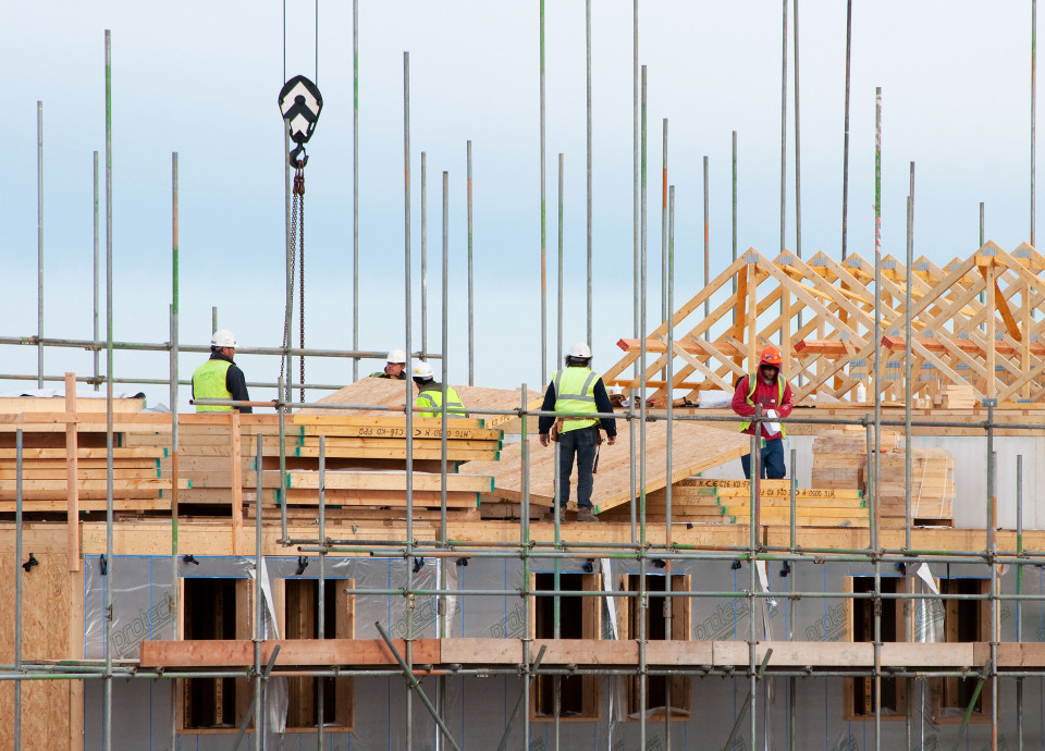 building contractors at work on housing on a construction site, cornwall, uk